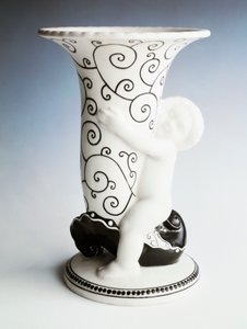 Wazon z czarną dekoracją, korpus w kształcie stożka trzymany przez cherubina, Vereinigte Wiener Und Gmundner Keramik, Austria, XX wiek (ceramika emaliowana na biało) autorstwa Michael Powolny