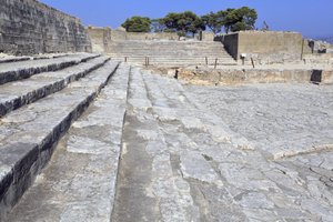 Minojskie stanowisko archeologiczne Fajstos. Zachodni dwór i obszar teatralny. Duży brukowany dziedziniec przed fasadą i centralnym wejściem do pałacu (1900 -1700 pne). Dwór ten odgrywał ważną rolę w życiu mieszkańców. U podnóża autorstwa Minoan