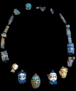 Naszyjnik ze szklanej pasty z zawieszkami przedstawiającymi brodate głowy, pochodzący z Olbii, obecnie przechowywany w Narodowym Muzeum Archeologicznym w Cagliari