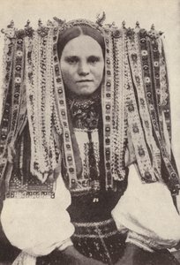 Czeszka w nakryciu głowy z wstążek, gdzie każda wstążka oznacza zalotnika, którego odmówiła w małżeństwie (zdjęcie czarno-białe)