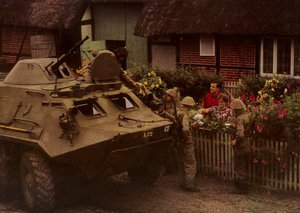 Podczas odpoczynku w marszu żołnierze Narodowego Ludowego Wojska Polskiego są serdecznie witani przez mieszkańców (kolorowe zdjęcie) autorstwa Photographer German