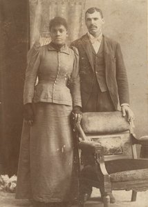 Zdjęcie afroamerykańskiej pary stojącej za krzesłem, ca. 1890. autorstwa Schmitz Studio