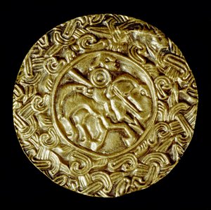 Archeologia średniowiecza (średniowiecze). Sztuka barbarzyńska Lombardii: złoty dysk. W centrum znajduje się święty na koniu z włócznią i wokół motywów zwierzęcych. Sztuka lombardzka, ok. 600. Wymiary: 47 cm Włochy, Cividale del Friuli, Muzeum Archeologicz autorstwa School Lombard