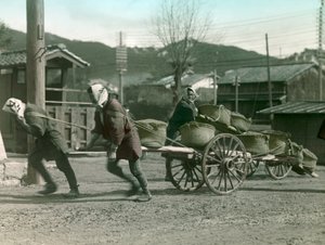 Japońscy chłopi ciągnący worki z ryżem na wózku, ok. 1900-1915 r. (zdjęcie)