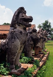 Kamienne postacie przypominające lwa strażników zbudowane wokół podstawy stupy autorstwa Thai School