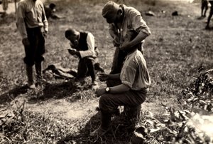 Więźniowie austriaccy podczas I wojny światowej w Bagnaria Arsa, Udine, Włochy; na pierwszym planie żołnierz goli kolegę żołnierza, 02.04.1916 (zdjęcie czarno-białe)
