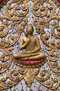 20151102, Vang Vieng, Laos : Drzwi wejściowe ozdobione złotymi płaskorzeźbami. Nauczający Budda przedstawia szczególny moment z życia Buddy, a mianowicie pierwsze kazanie wygłoszone przez Buddę po osiągnięciu Oświecenia autorstwa Unbekannt