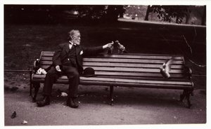 Mężczyzna na ławce w parku, ok. 1920 r. Migawkowe zdjęcie mężczyzny siedzącego na ławce w parku karmiącego gołębie, wykonane przez nieznanego fotografa ok. 1920 r. autorstwa Unbekannt
