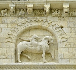 Sztuka romańska: detal fasady przedstawiający Hugues de Surgeres i Geoffroy de Vendome lub cesarza Konstantyna I Wielkiego, którego stopa konia stąpałaby po Herezji i Chrystusa triumfującego nad złem i śmiercią, Notre Dame (Notre-Dame) de Surgeres (17700) autorstwa Unbekannt
