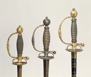 Rękojeści trzech mieczy francuskich: jeden ze stali, oksydowany na niebiesko i pokryty wzorami ze złota, ok. 1730; jeden ze stali przekłuty i wyrzeźbiony i szlifowany z matowego złota, ok. 1760; jeden z rzeźbionej stali, gr autorstwa Unbekannt Unbekannt