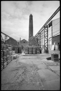 Ogólny widok Elswick Shot Tower, zburzonej w latach 1968-69, służącej do tworzenia ołowianych ujęć, z dziedzińcem z paletami na pierwszym planie, ok. 1955-69 (fot. czarno-białe) autorstwa Unbekannter Künstler