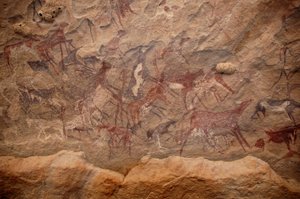 Sztuka naskalna, prehistoria: Malowidło naskalne przedstawiające grupę bydła i polichromowane postacie w ozdobnym schronie w masywie Uweinat w Sudanie. Okres od 8000 do 3000 lat pne. Fotografia autorstwa Unbekannt