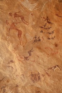Sztuka naskalna, prehistoria: Malowidło naskalne przedstawiające dużą grupę postaci i bydła w ozdobnym schronie w masywie Uweinat w Egipcie. (Okres od 8000 do 3000 lat pne). Fotografia autorstwa Unbekannt