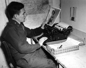 Druga wojna światowa (1939-1945) – II wojna światowa (II lub II wojna światowa): Mutzig (Alzacja) Francja 1 grudnia 1944: kapral Flanerty kronikarz z Beachead News (dziennika wiadomości GI) patrzy na pin-upowe zdjęcie, które publikuje w kolejny numer gazet autorstwa Unbekannt