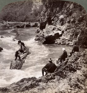 Mężczyźni na tratwie z bali, strzelający do potoku Hozu na rzece Katsura, Kioto, Japonia, 1904 autorstwa Underwood and Underwood