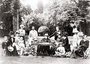 Członkowie brytyjskiej rodziny królewskiej, w tym król Jerzy V, król Edward VIII wokół królowej Wiktorii na przyjęciu w ogrodzie. Fotografia w latach 1895-1901. autorstwa Unknown photographer