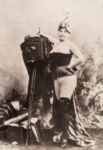 Portret częściowo nagiej kobiety opierającej się o zabytkowy aparat. autorstwa Unknown photographer