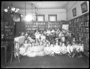 Portret grupowy dzieci w czytelni niezidentyfikowanej filii biblioteki publicznej w dzielnicy Queens, ok. 1910 r. autorstwa William Davis Hassler