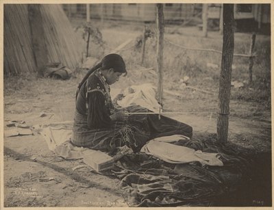 [Kobieta z narodu Meskwaki zajmująca się koralikami].
 autorstwa Adolph F. Muhr