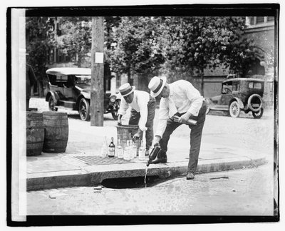 Dwóch mężczyzn nalewających alkohol do kanalizacji deszczowej, 8 lipca 1921 (zdjęcie czarno-białe) autorstwa American Photographer