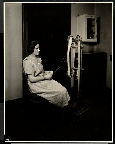 Portret niewidomej, głuchej i niemej młodej kobiety przędzącej wełnę w nowojorskim stowarzyszeniu dla niewidomych, 111 East 59th St., Nowy Jork, 1923 (srebrny odbitka żelatynowa) autorstwa Byron Company
