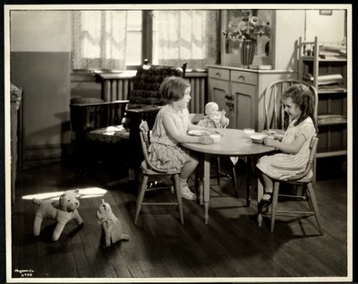 Dwie niewidome, niedowidzące dziewczyny jedzące przy małym stoliku z lalką w nowojorskim stowarzyszeniu dla niewidomych, 111 East 59th Street, Nowy Jork, 1933 (srebrny odbitka żelatynowa) autorstwa Byron Company