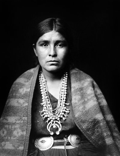 Kobieta Navajo nosząca srebrny naszyjnik z kwiatów kabaczka, pas concho, koc narzucony na ramiona, ok. 1904, fot. Edward S. Curtis autorstwa Edward Sheriff Curtis
