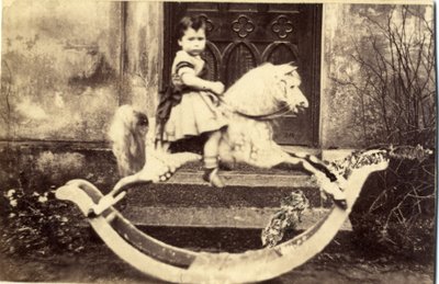 Mała dziewczynka na dużym koniu na biegunach w ogrodzie, lata 60. XIX wieku (druk albumowy) autorstwa English Photographer
