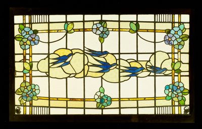 Panel Arts and Crafts przedstawiający grupę jaskółek przed chmurami w obramowaniu stylizowanych główek kwiatów (ołów i witraż) autorstwa English School