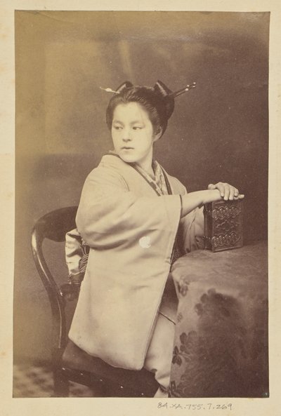 [Siedząca Japonka trzymająca przy stole album cartes-de-visite]. autorstwa Felice Beato
