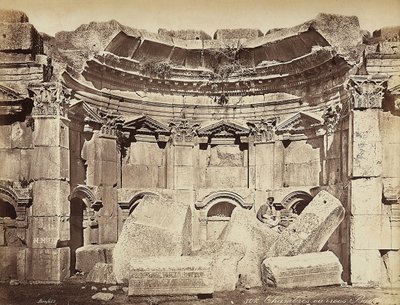 Fragment tzw. „pokojów” w strefie archeologicznej Heliopolis lub Baalbek, starożytnego syryjskiego miasta, obecnie Libanu. Mężczyzna pozuje, siedząc na ruinach autorstwa Félix Bonfils