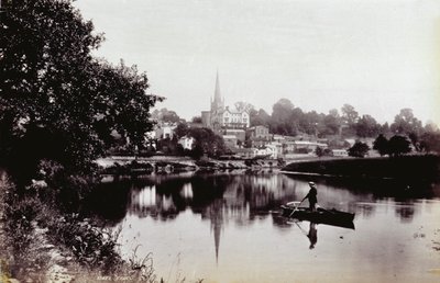 Miasto Ross-On-Wye, widziane z brzegu rzeki. Na pierwszym planie mężczyzna stojący na łodzi wiosłowej autorstwa Francis Frith