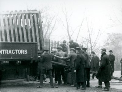 Tłum gapiów stoi, gdy nosorożec jest rozładowywany z ciężarówki przez opiekunów w londyńskim zoo w 1924 roku autorstwa Frederick William Bond