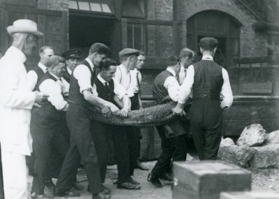 Zespół mężczyzn niesie aligatora, nad którym czuwa Sir Peter Chalmers Mitchell, londyńskie zoo, 1924 autorstwa Frederick William Bond
