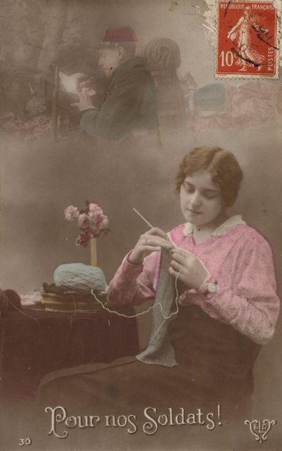 Młoda kobieta robi na drutach, myśląc o swoim żołnierzu, który pisze list do domu (przyciemnione zdjęcie) autorstwa French Photographer