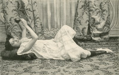 Dziewczyna leżąca na podłodze trzymająca piłkę nad głową (zdjęcie czarno-białe) autorstwa French Photographer