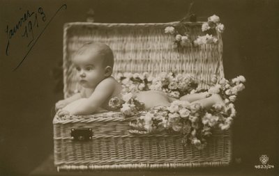 Pocztówka przedstawiająca dziecko w wiklinowym koszu z kwiatami, wysłana w styczniu 1913 r. autorstwa French Photographer