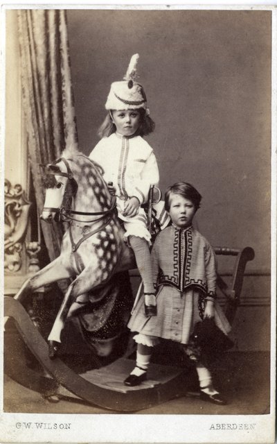 Młoda dziewczyna w kapeluszu na koniu na biegunach z inną dziewczyną stojącą obok, lata 60. XIX wieku (druk albumowy) autorstwa George Washington Wilson