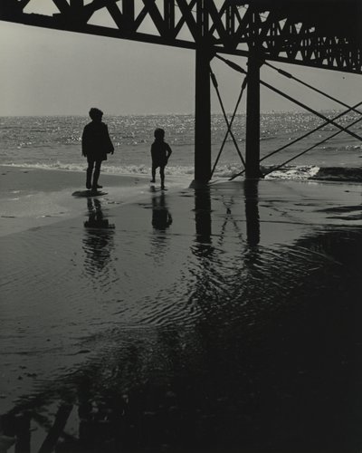 Dwoje dzieci bawiących się na plaży. autorstwa Godfrey Macdominic