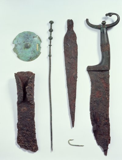 Od góry do dołu: nóż, grot, haczyk na ryby, szpilka do ubrania, dysk do paska i topór, wszystkie znalezione w męskich grobach w Hallstatt, epoka żelaza autorstwa Iron Age