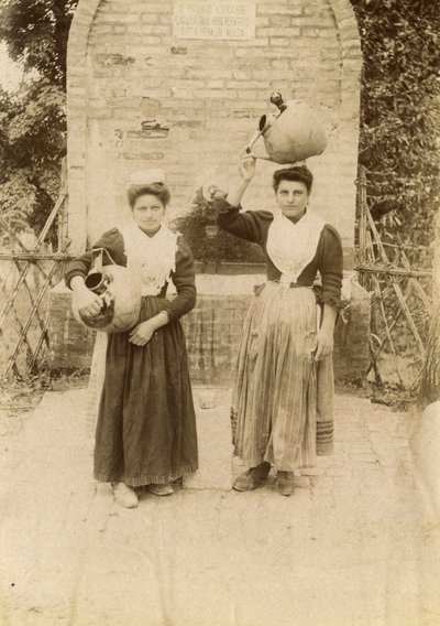 Dwie młode kobiety w tradycyjnych strojach niosące słoiki z terakoty w pobliżu studni, Marche, Włochy, ok. 1910 r. autorstwa Italian Photographer