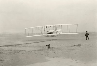 Wright Flyer I wykonuje swój pierwszy lot 120 stóp w 12 sekund, w Kitty Hawk w Północnej Karolinie autorstwa John T. Daniels
