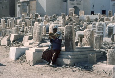 Jemeńczyk recytuje Koran na cmentarzu z grobowcami w Sayun, Hadramawt, Jemen Południowy. autorstwa Lynn Abercrombie