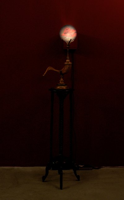 Horn Blower, 2002 (szkło, woda, mosiądz, róg barani, drewno, projektor wideo i odtwarzacz) autorstwa Mat Collishaw