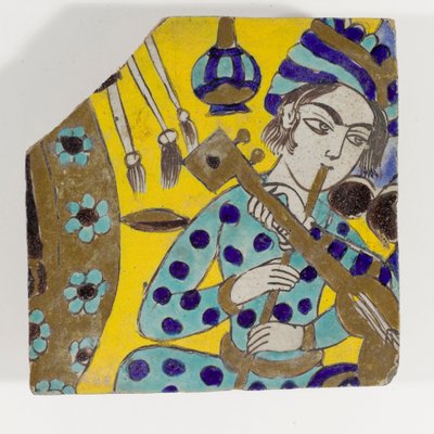 Płytka ceramiczna Safavid Persia cuerda seca z końca XVII wieku przedstawiająca mężczyznę grającego na flecie w turbanie autorstwa Persian School