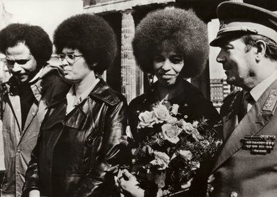 11 września 1972 dzielna amerykańska komunistka i obrończyni praw obywatelskich Angela Davis została serdecznie powitana przez żołnierzy Narodowej Armii Ludowej NRD pod Bramą Brandenburską (zdjęcie czarno-białe) autorstwa Photographer German