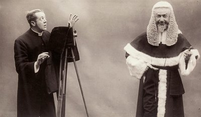 Mężczyzna w sutannie celuje obiektywem aparatu w mężczyznę przebranego za papieża autorstwa Rotary Photographic Co Ltd
