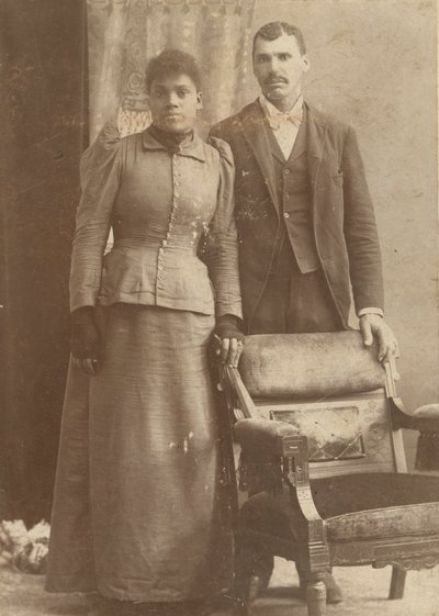 Zdjęcie afroamerykańskiej pary stojącej za krzesłem, ca. 1890. autorstwa Schmitz Studio
