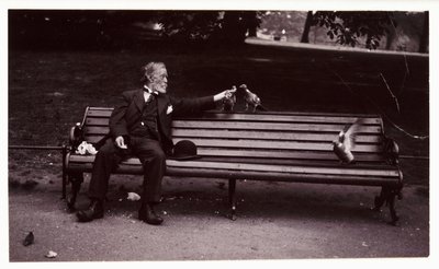 Mężczyzna na ławce w parku, ok. 1920 r. Migawkowe zdjęcie mężczyzny siedzącego na ławce w parku karmiącego gołębie, wykonane przez nieznanego fotografa ok. 1920 r. autorstwa Unbekannt