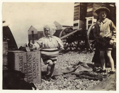 Dwoje dzieci przy maszynach do kąpieli, ok. 1895, Migawkowe zdjęcie dwójki dzieci nad morzem, stojących wśród grupy maszyn do kąpieli na plaży autorstwa Unbekannt
